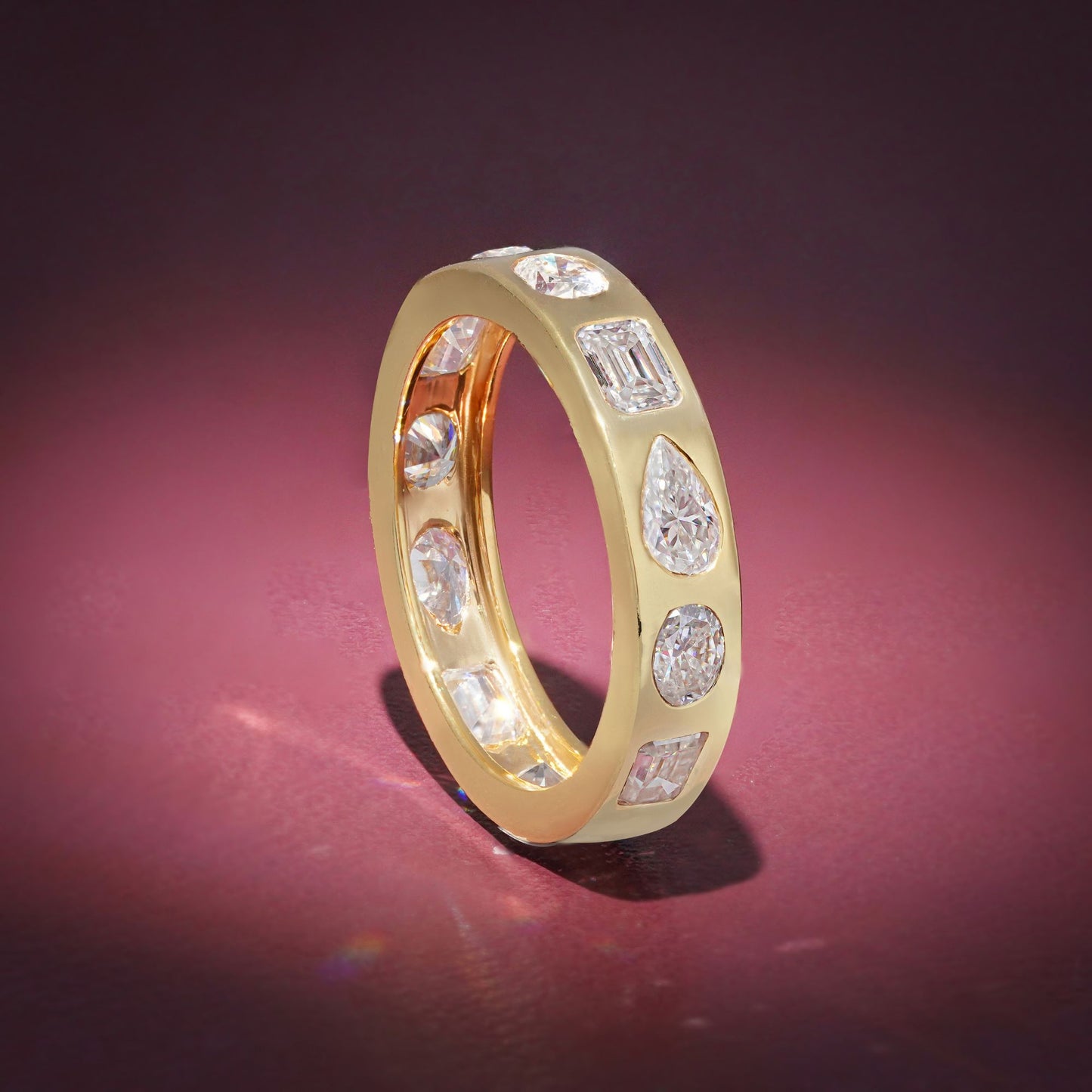 Gold Band Ring Featuring Mix Of Bezel-Set Diamonds Including Oval, Pear And Emerald Cuts Creating A Modern And Luxurious Multi-Shape Design