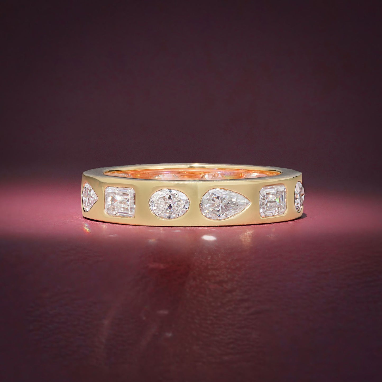 Gold Band Ring Featuring Mix Of Bezel-Set Diamonds Including Oval, Pear And Emerald Cuts Creating A Modern And Luxurious Multi-Shape Design